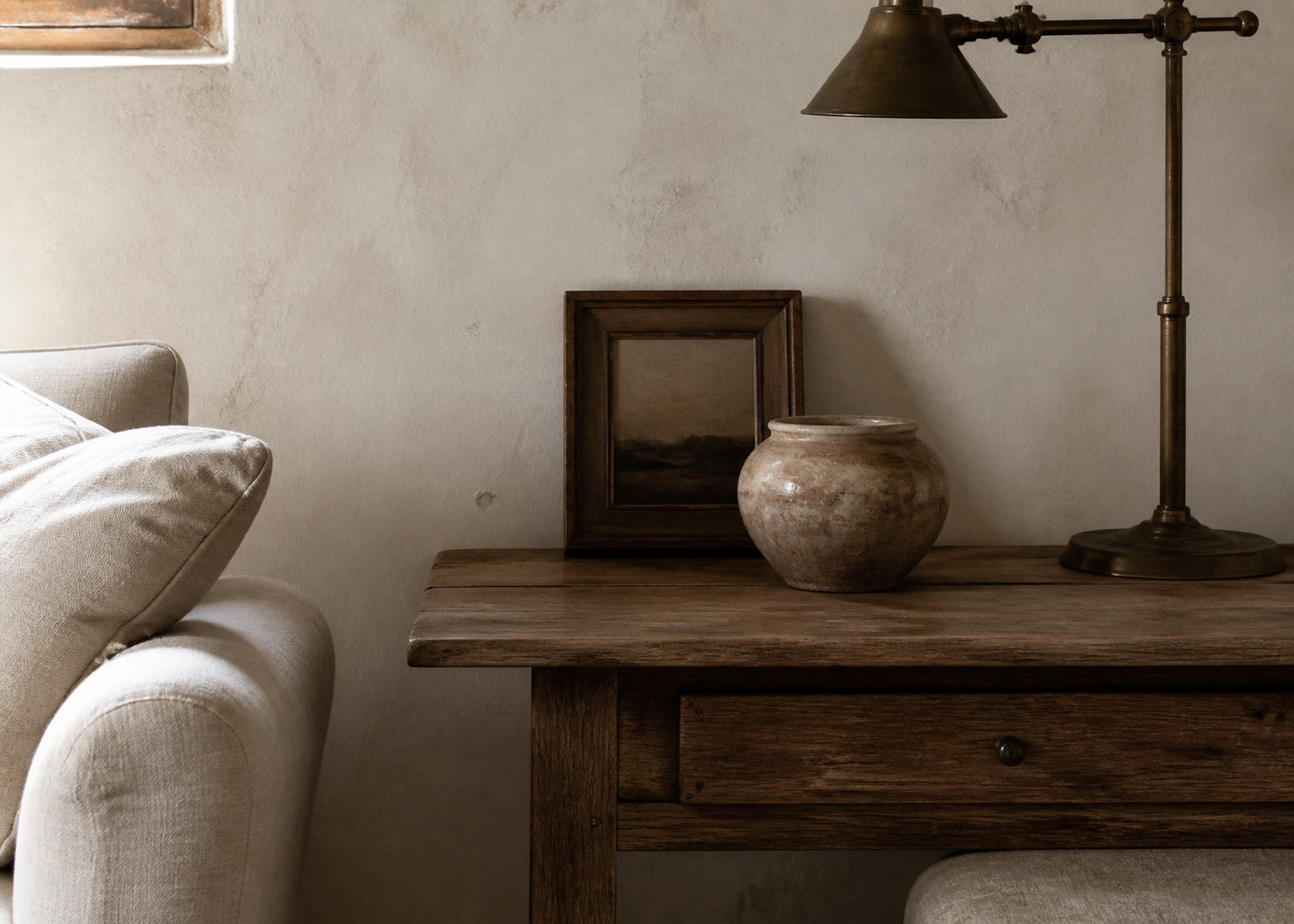 Aged oak, patinated brass, and ceramics give the neutral palette specificity.