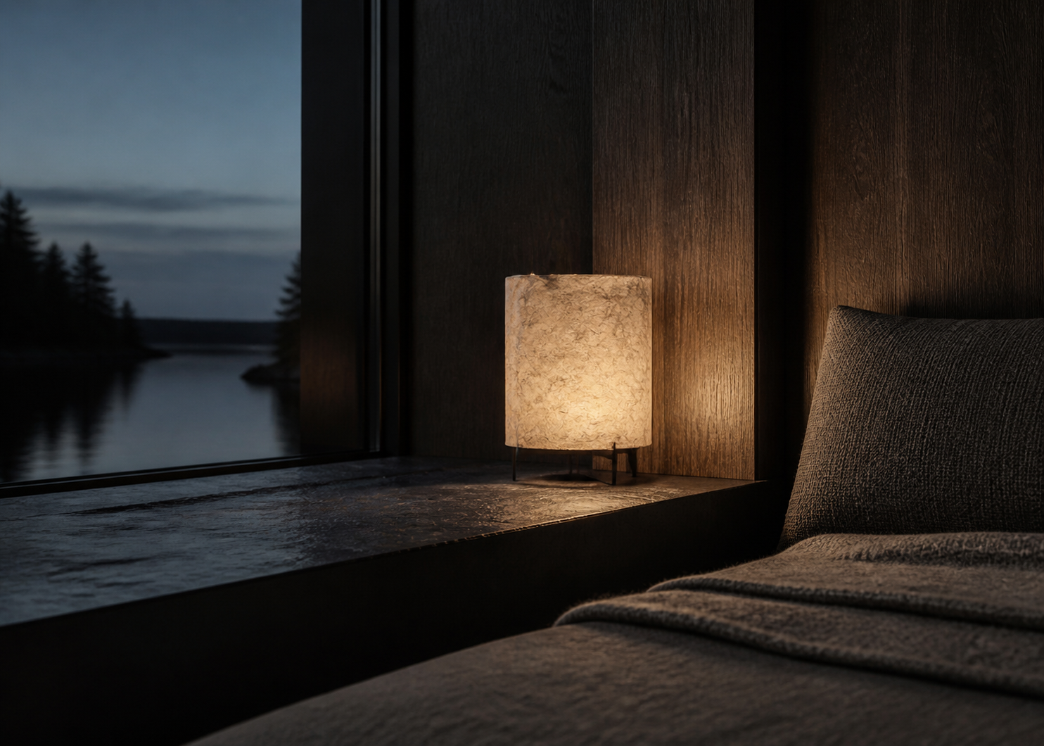 Paper, wool, and indirect light soften the slate and smoked-oak palette.